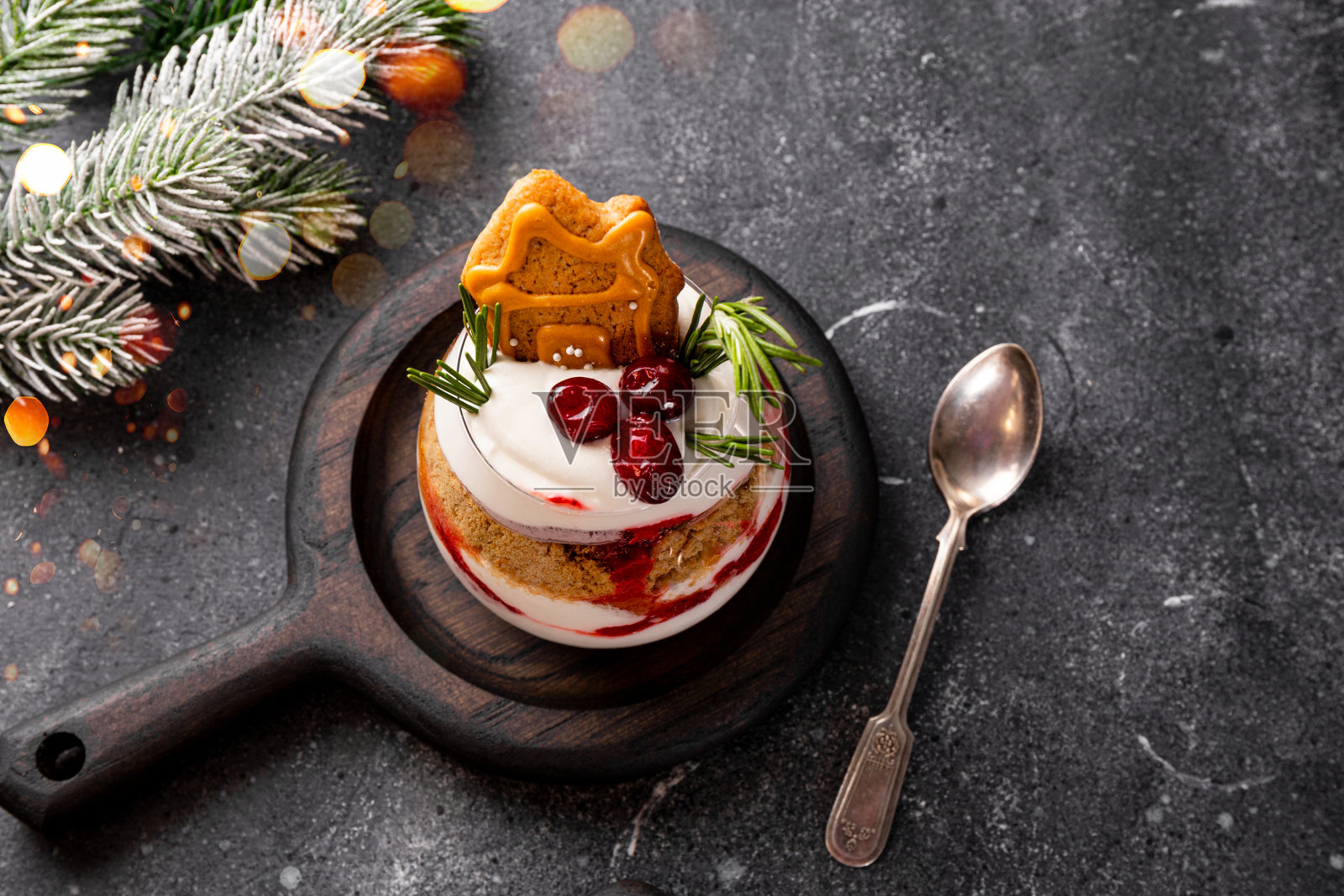 一杯圣诞甜点,配有姜饼饼干、鲜奶油和灰色背景的蔓越莓照片摄影图片