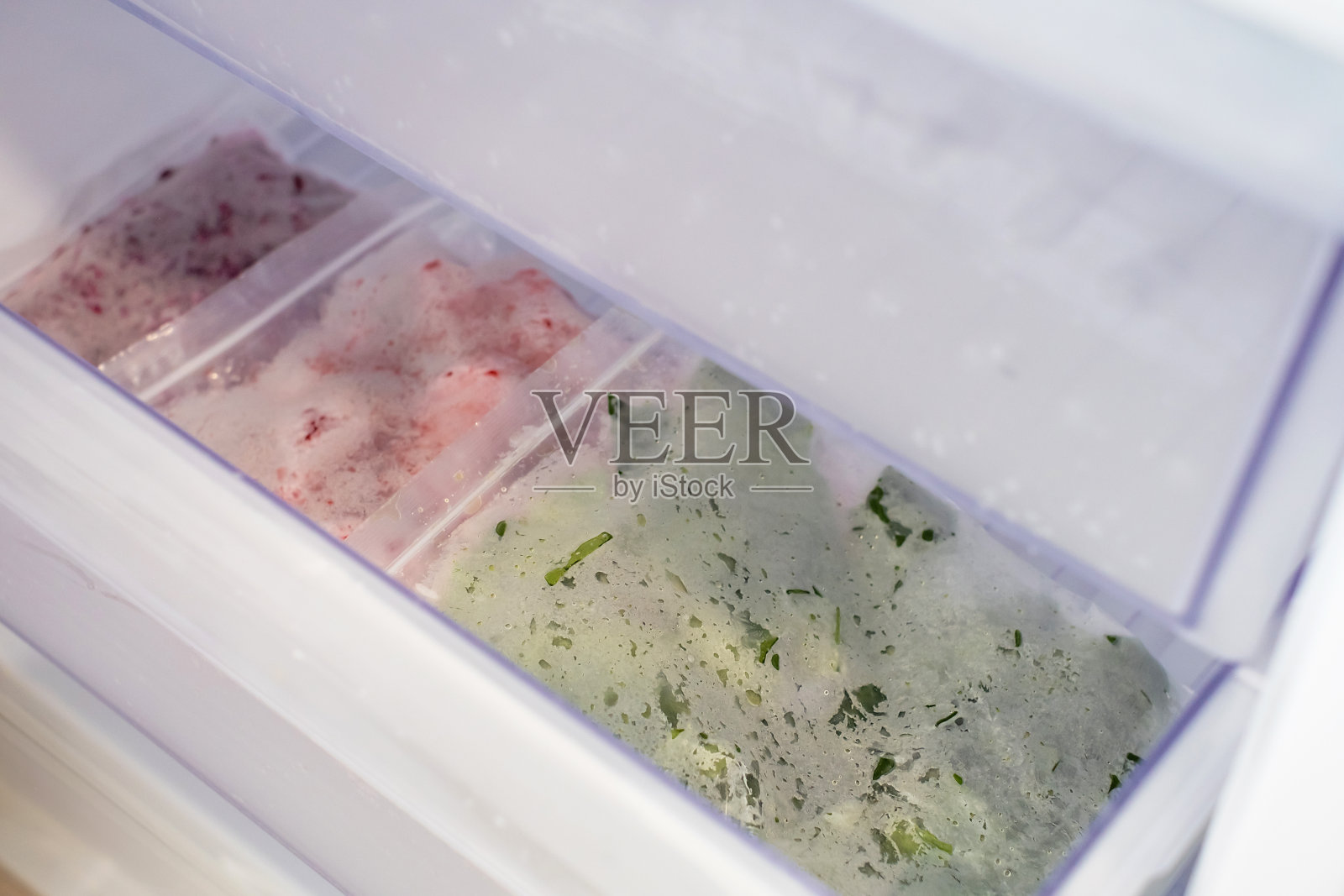 冰箱里装着塑料袋的冷冻蔬菜特写,俯视图。照片摄影图片