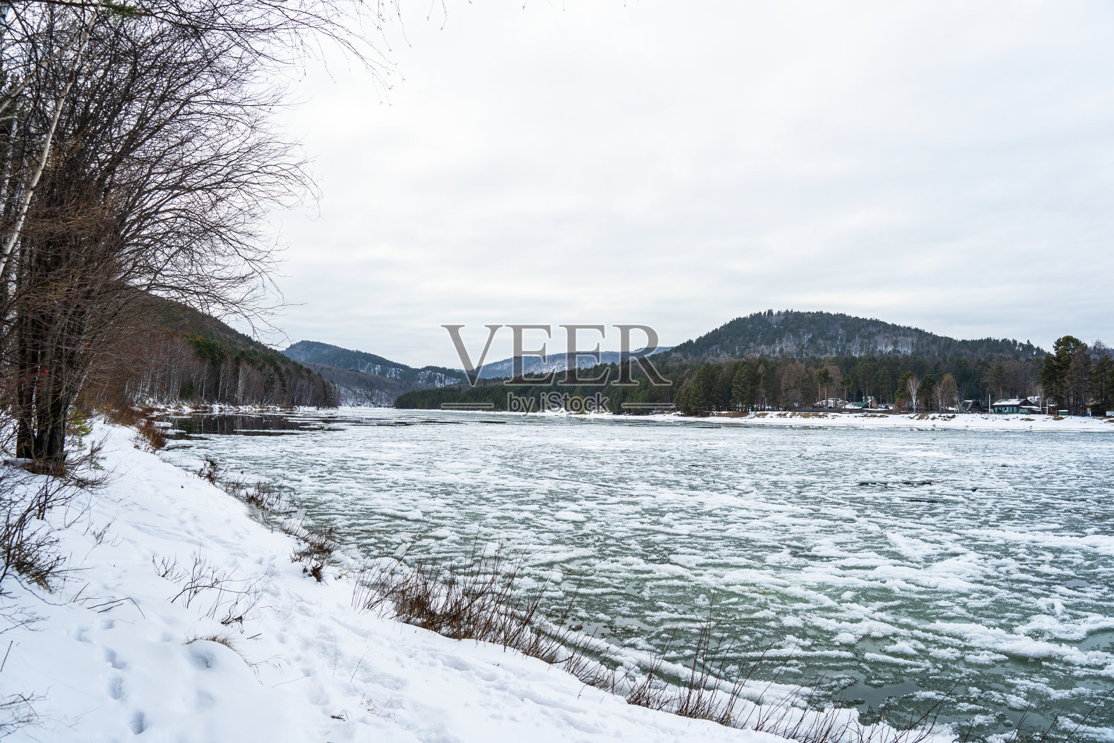 冬天流动的河流。有河流和冬季森林的冬季景观。冬天的树林里有冰雪的河流。照片摄影图片
