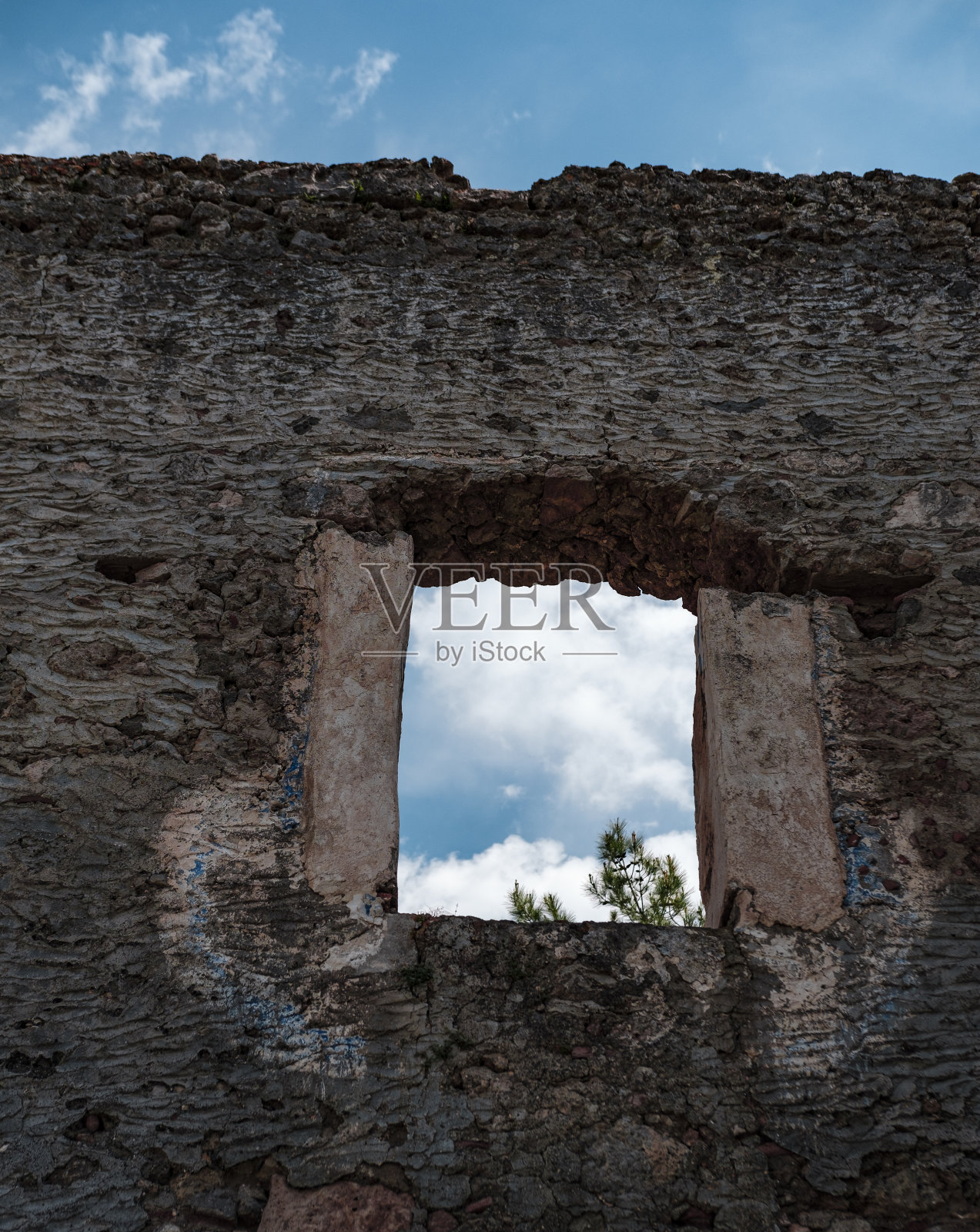 在废弃的石屋废墟中打开窗户,眺望蓝天照片摄影图片