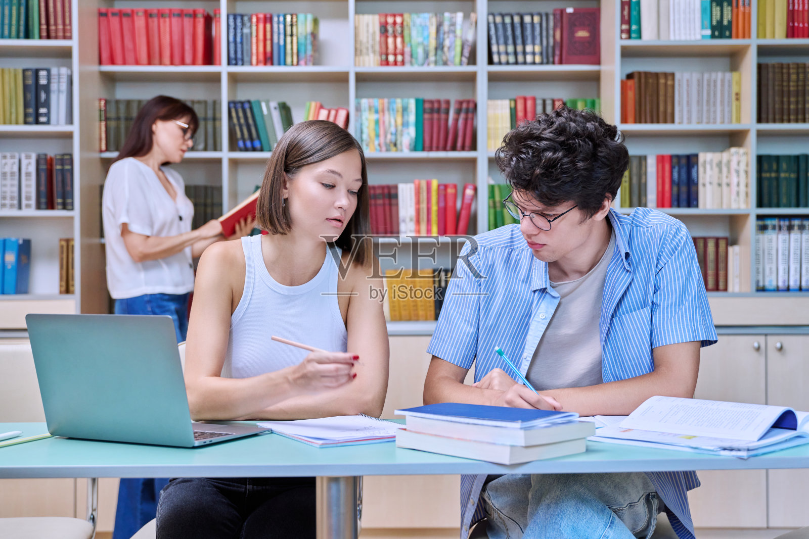 大学生男女在图书馆学习照片摄影图片