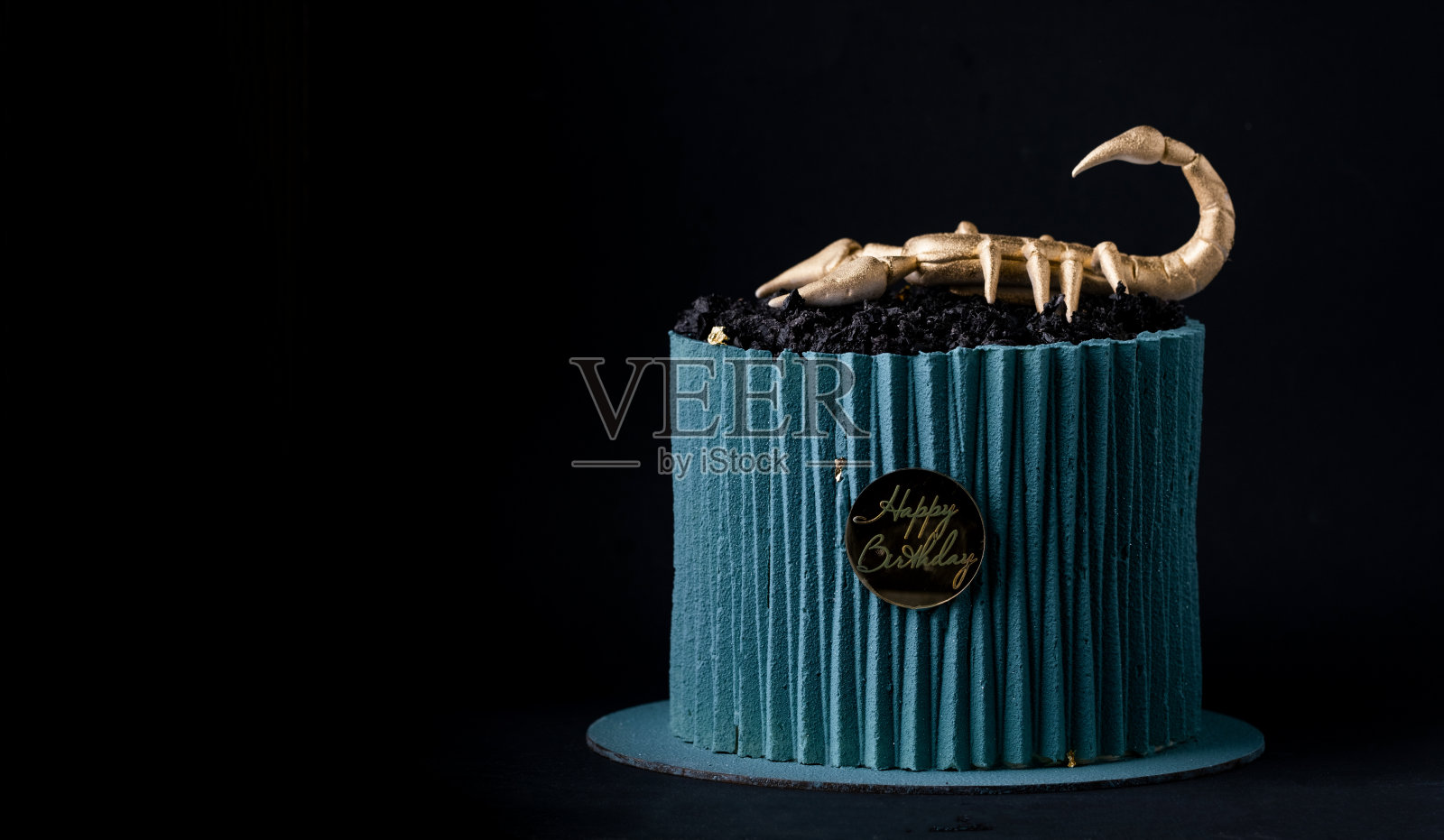 蛋糕用瓦楞纸形状的绿松石巧克力糖霜装饰,上面装饰着可食用的金蝎子。生日蛋糕的天蝎座标志的十二生肖在黑色的背景照片摄影图片