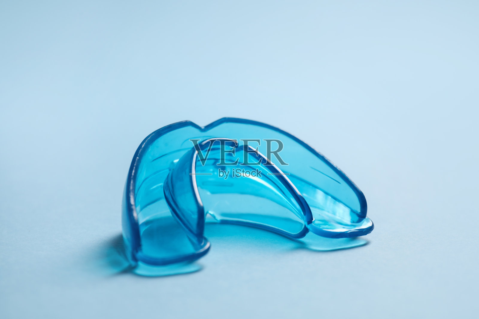 浅蓝色背景的牙护套,特写。咬校正照片摄影图片