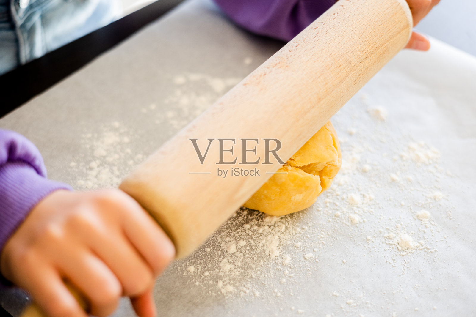 孩子的手在近距离擀酥皮面团照片摄影图片