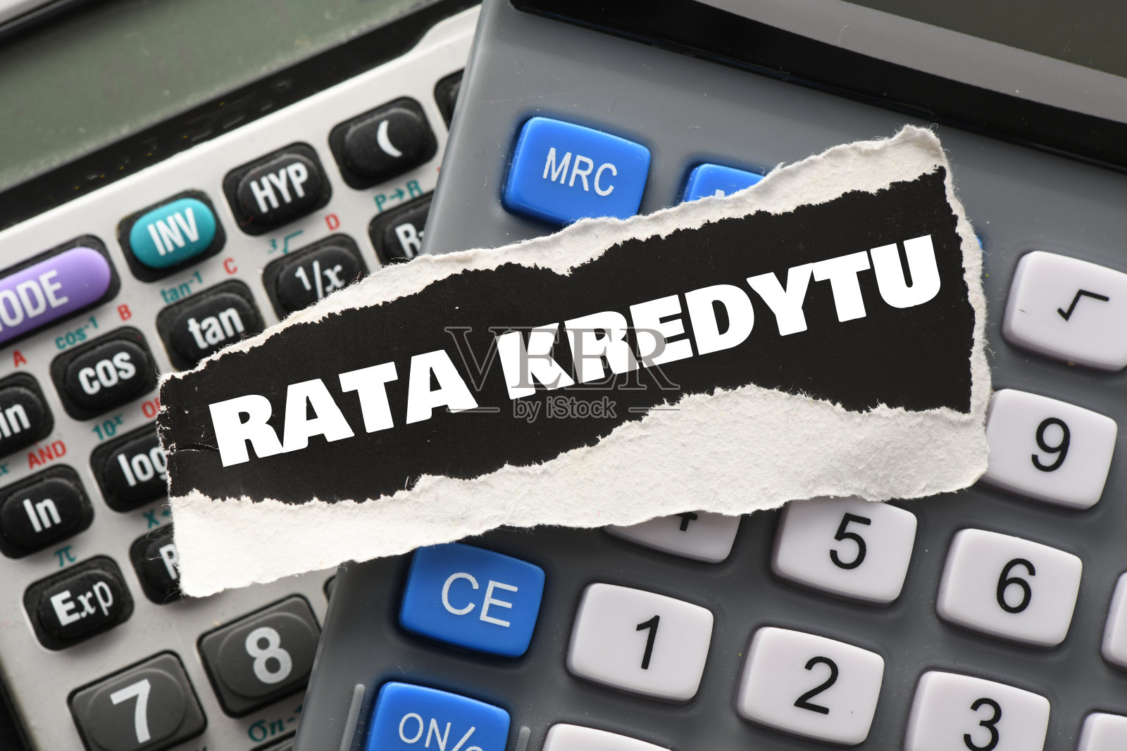 在计算器上放着一张黑色的纸,上面写着“贷款分期付款”。照片摄影图片