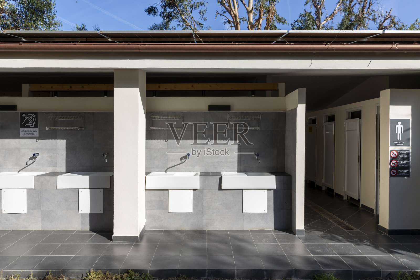 白色陶瓷水槽,在露营地的天篷下洗衣服。照片摄影图片