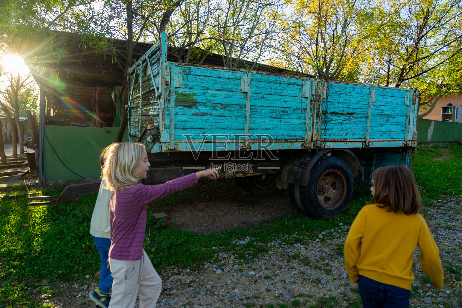 三个孩子在学校的农场里玩耍照片摄影图片
