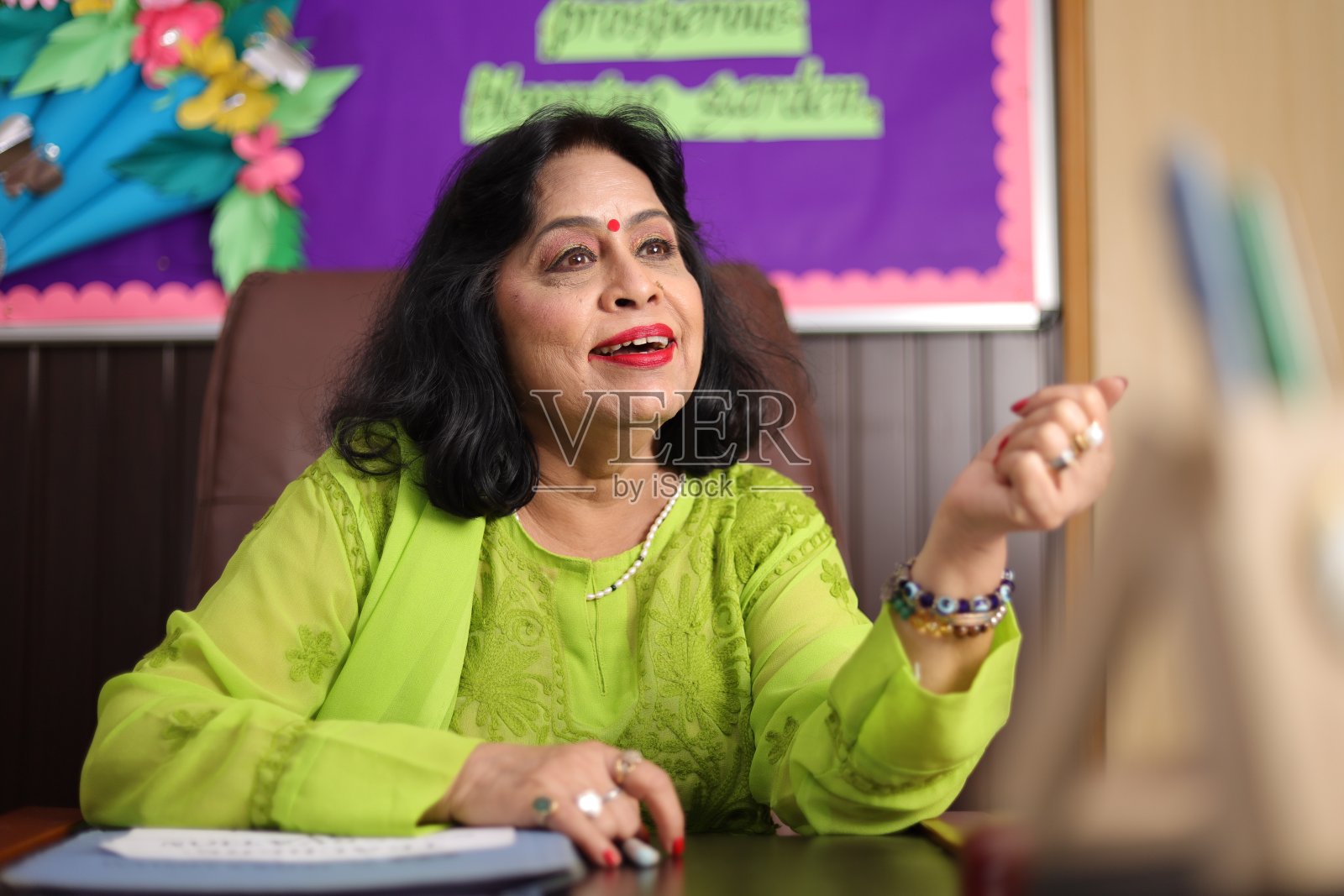 校长高兴地坐着,为她学校的学生们感到骄傲,面带微笑照片摄影图片