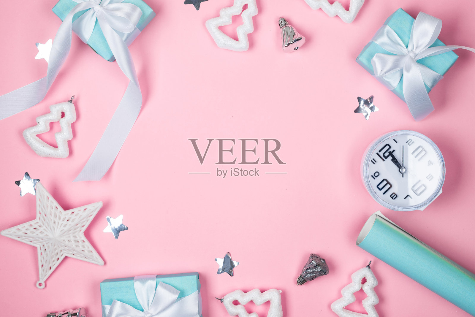 粉色背景上用蓝色纸包裹的节日礼品盒、彩球和闪光片照片摄影图片