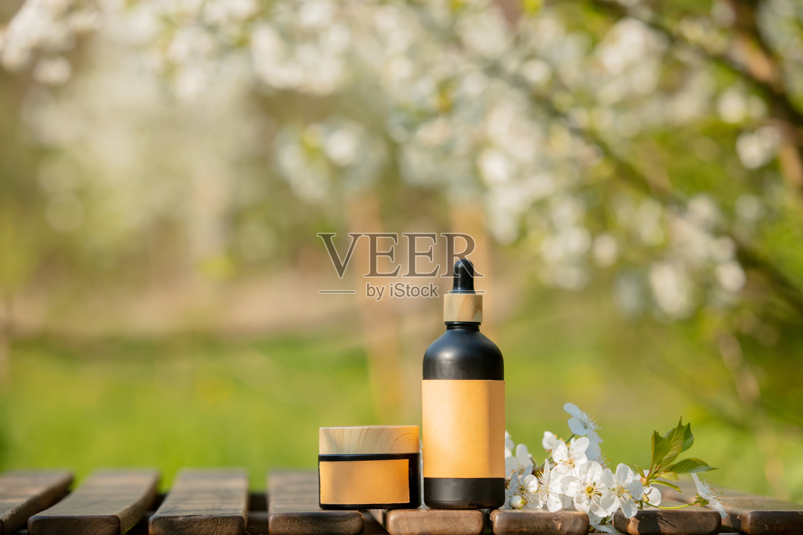 花木春园木桌上的化妆品瓶照片摄影图片