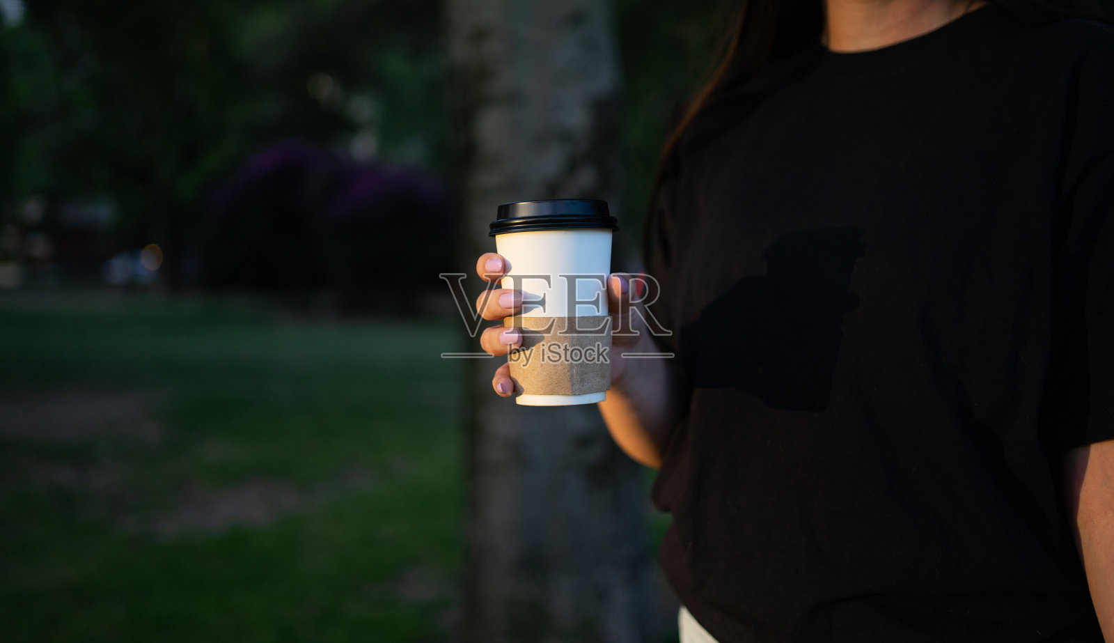 一个女孩在户外公园享受着一杯咖啡。有空间用于复制。照片摄影图片