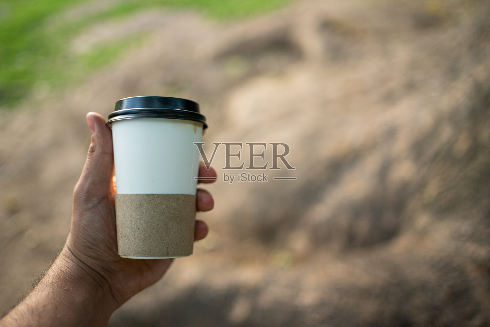 一个人在户外公园拿着咖啡。与Copyspace照片摄影图片