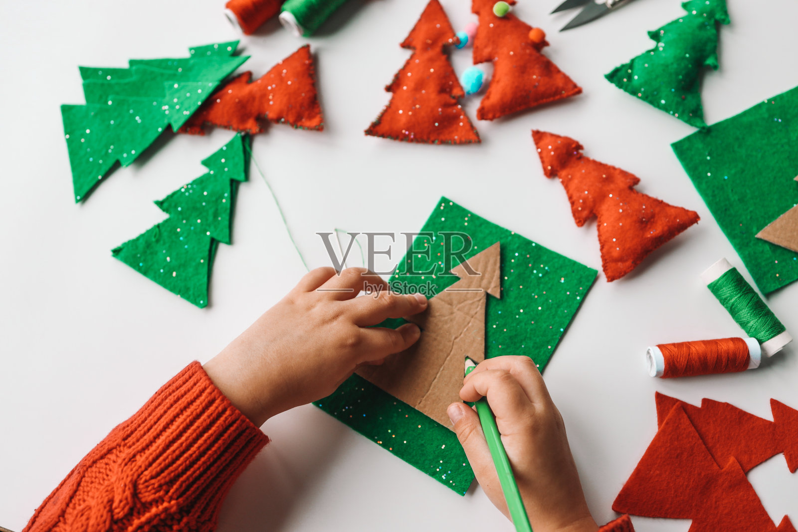 手工缝制软玩具的过程,用毛毡和针装饰圣诞树照片摄影图片