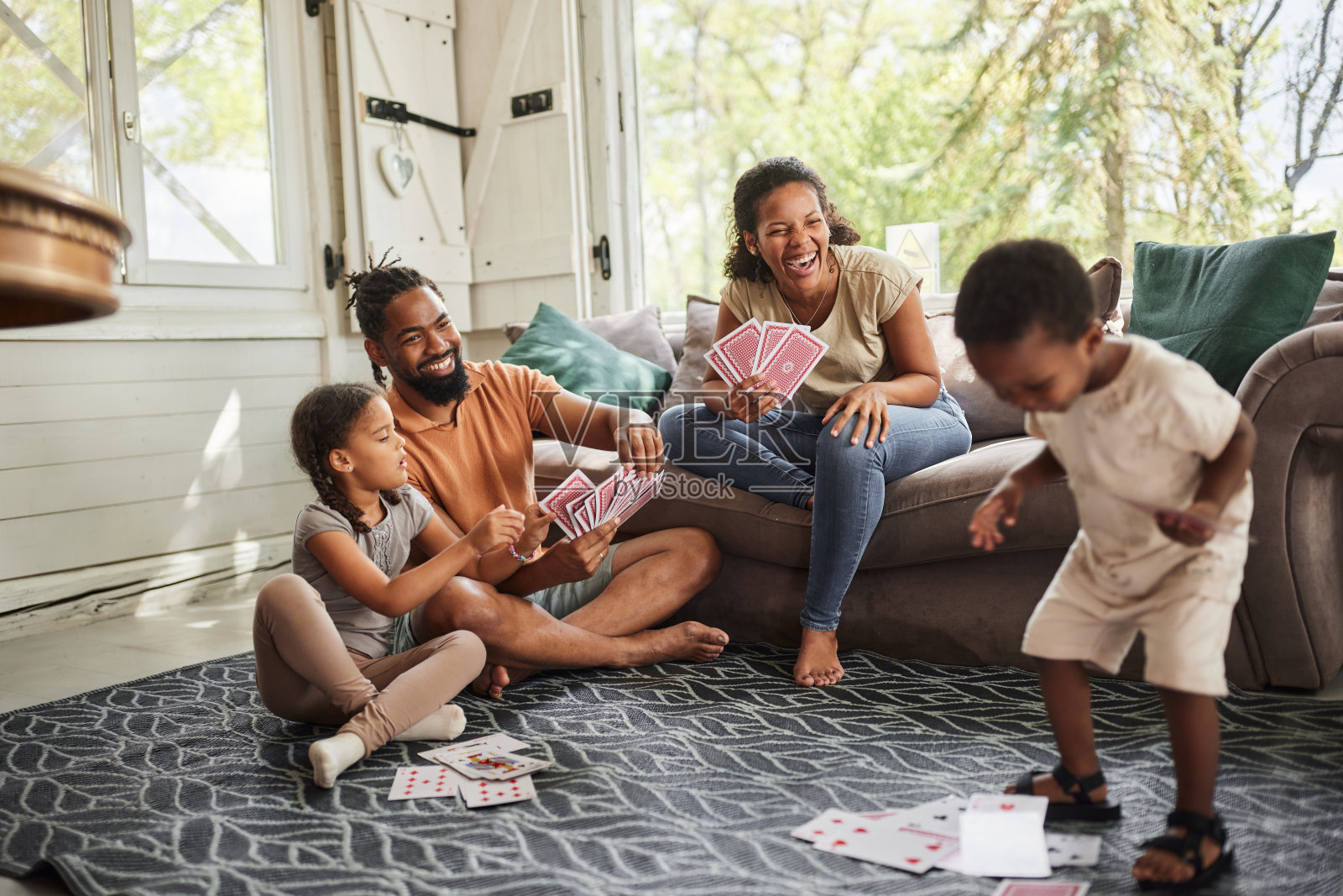 快乐的黑人家庭在客厅打牌。照片摄影图片