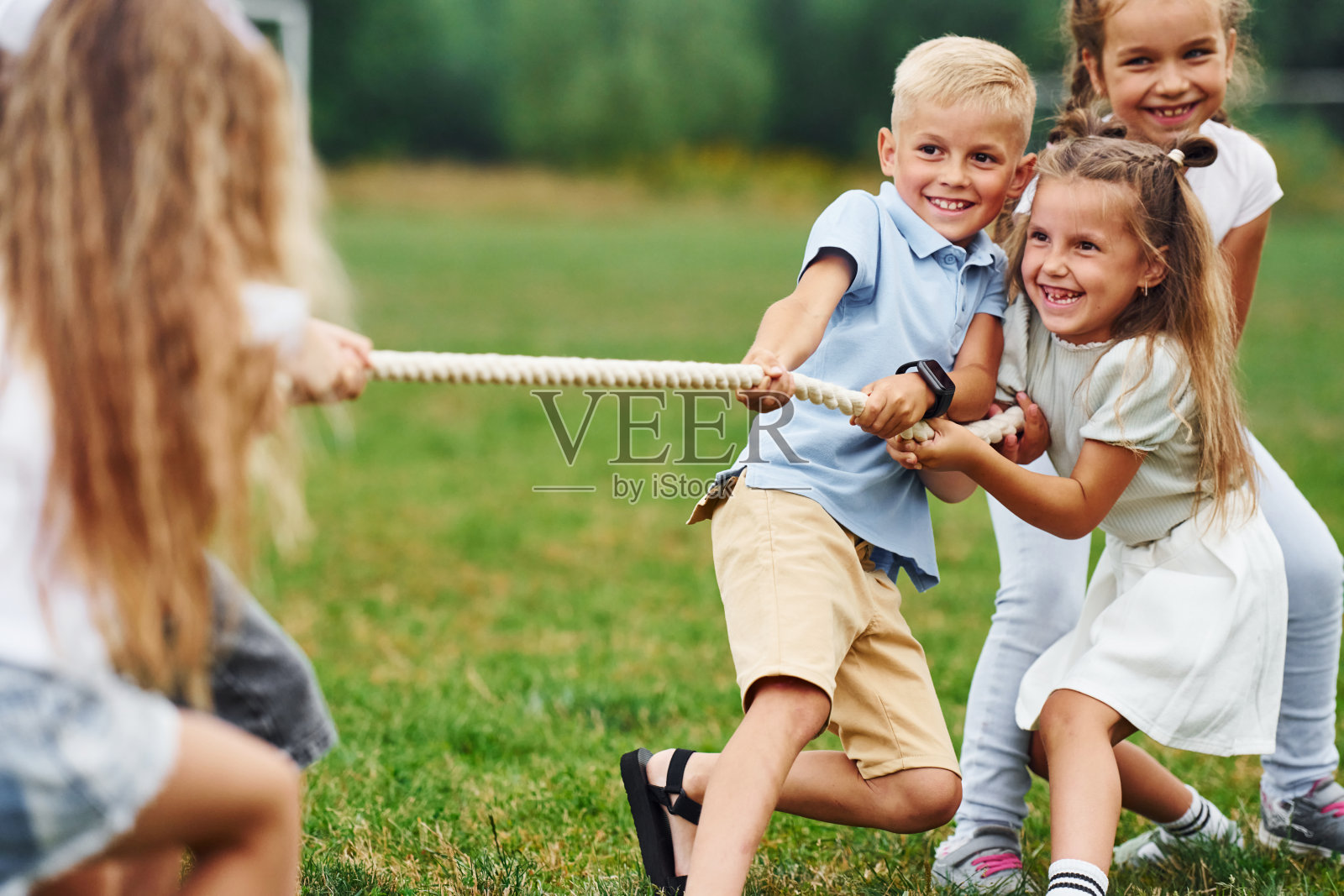 微笑着,玩拔河游戏。孩子们白天一起在操场上玩得很开心照片摄影图片