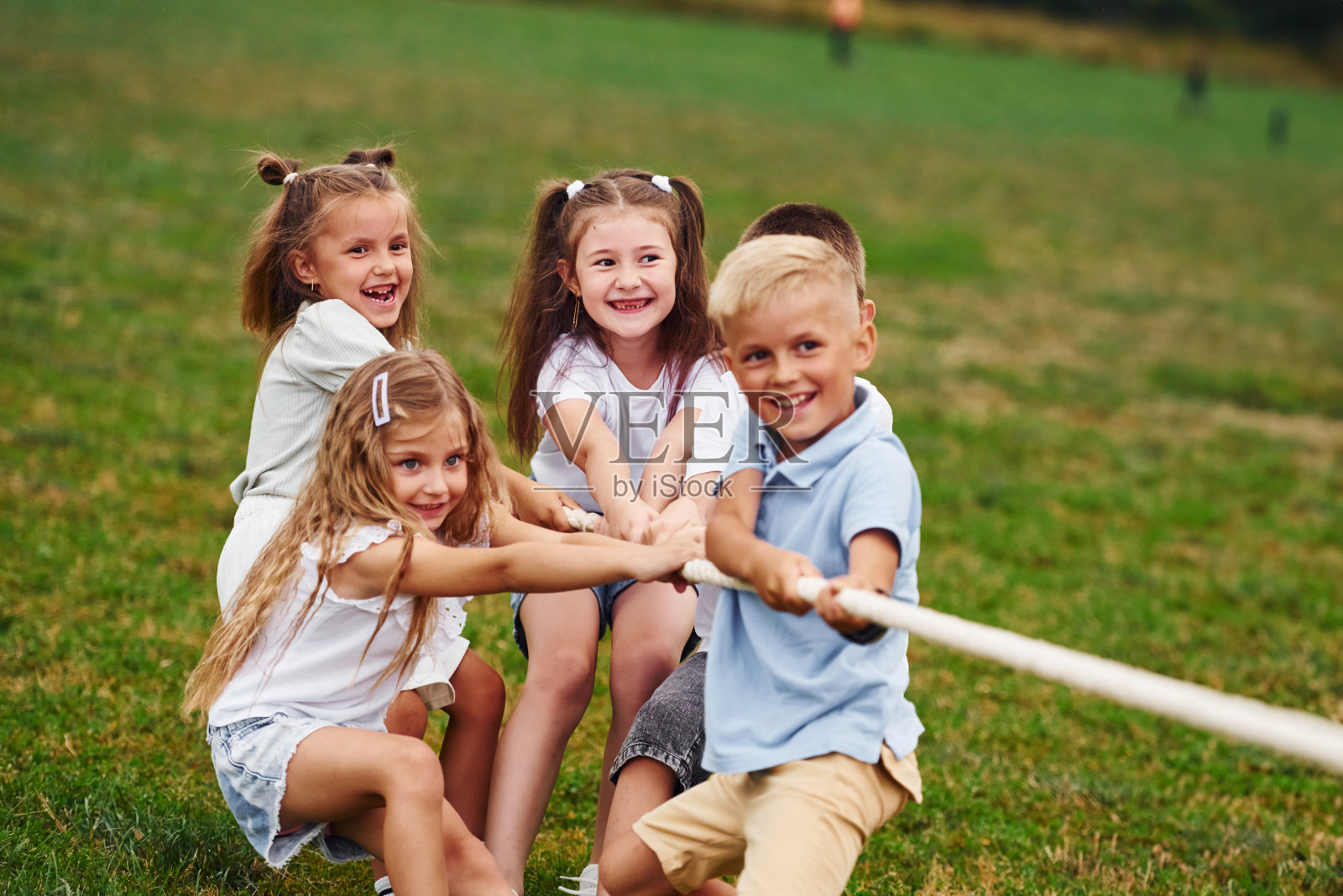 实力游戏。拔河游戏。孩子们白天一起在操场上玩得很开心照片摄影图片