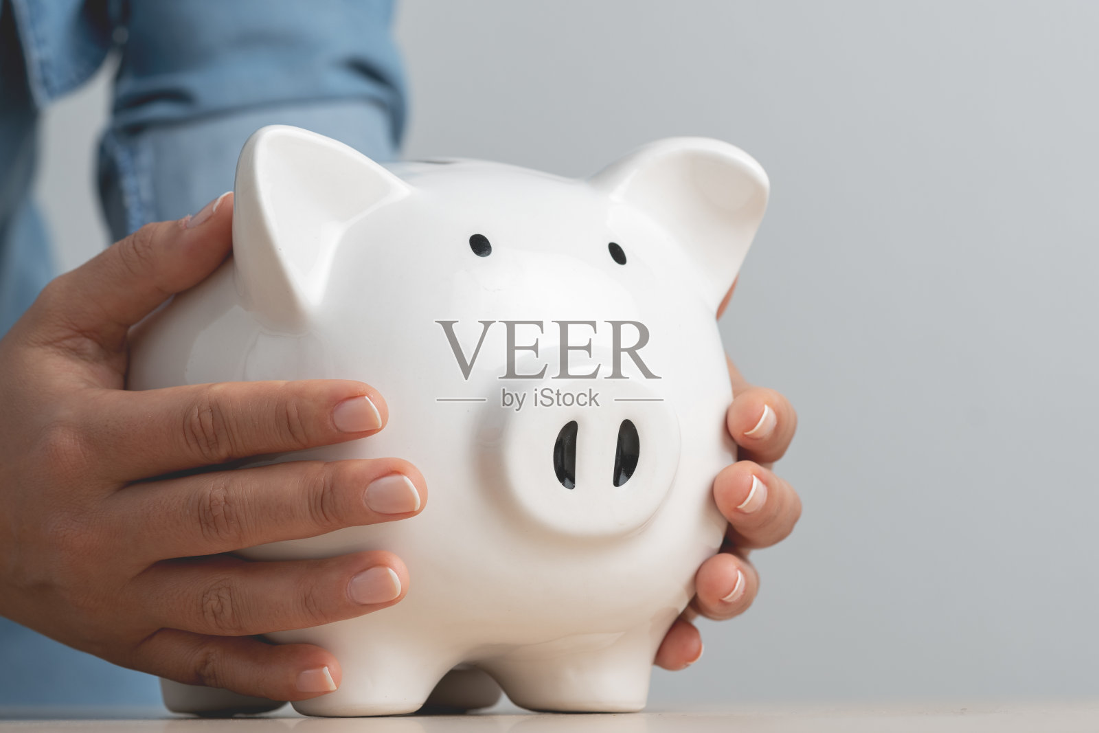 商人将手交给粉红色的储蓄罐作为投资银行存款照片摄影图片