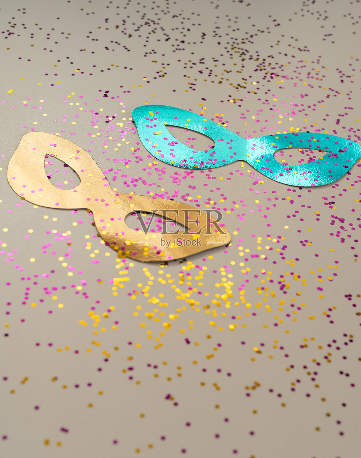 金色和蓝色的金属面具背景的彩色和闪亮的五彩纸屑为化妆舞会庆祝活动照片摄影图片