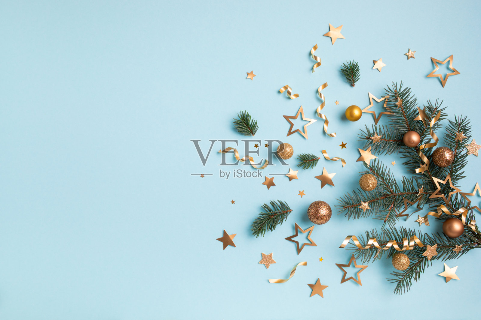 圣诞和新年贺卡从冷杉树枝,金色的派对彩纸星星和节日装饰俯视图。照片摄影图片