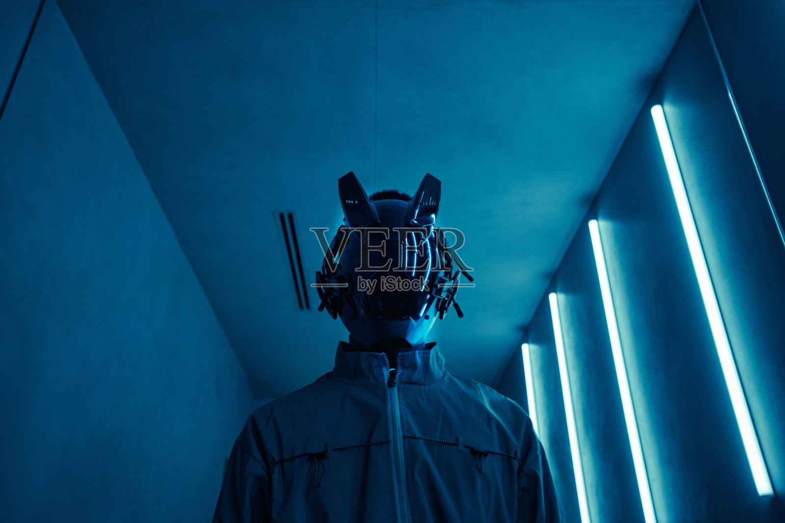 戴着蓝色霓虹灯赛博朋克机器人面具的人照片摄影图片