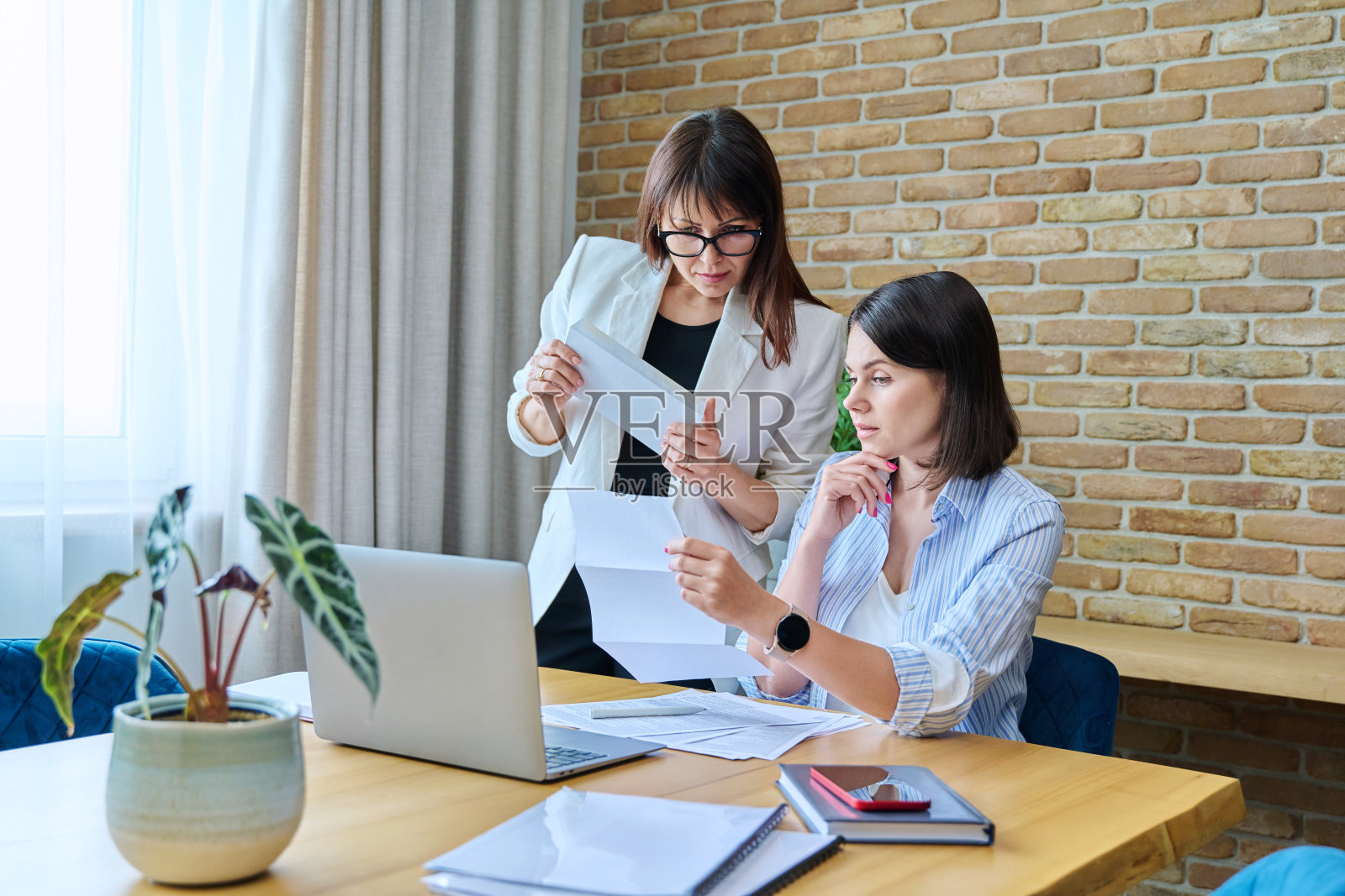 两个严肃的商务女性谈论在现代办公室的工作照片摄影图片