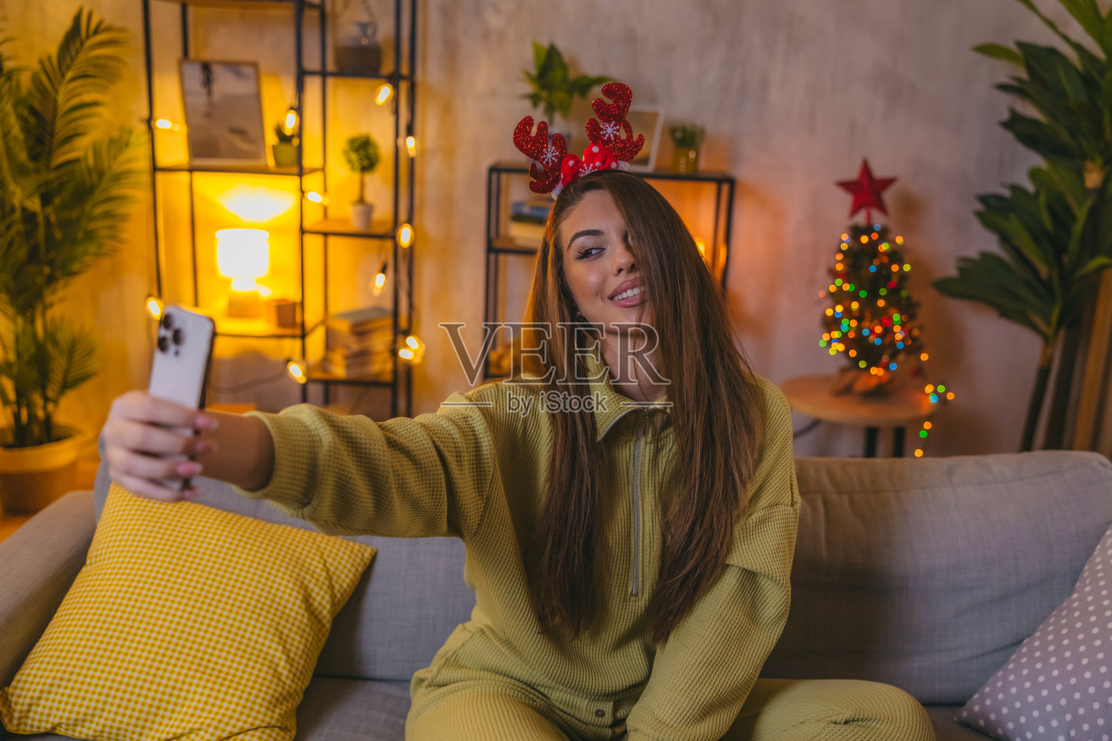 美丽的年轻女子在圣诞节期间在家自拍照片摄影图片