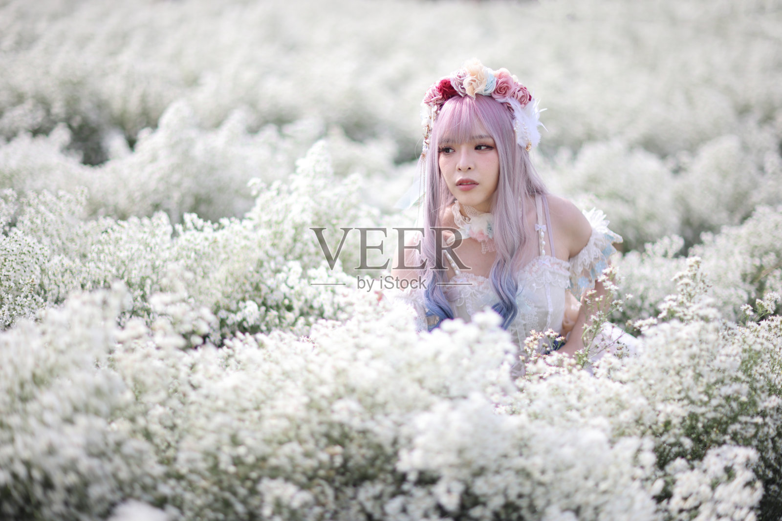 美丽的年轻女子穿着白色的洛丽塔连衣裙,带着日本花园的花朵照片摄影图片