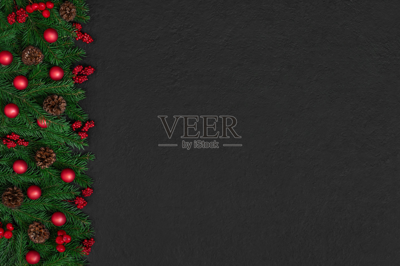 圣诞边界与红色的节日配件,锥体和冷杉树枝在黑色的背景。新年。贺卡。复制空间,模板。俯视图,平铺。照片摄影图片