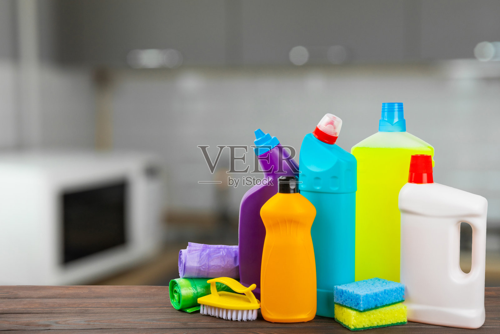 厨房背景模糊,木桌上的清洁用品。清洁服务理念。家庭化学物质。用塑料瓶、海绵和手套清洗和洗洁精。设计。照片摄影图片