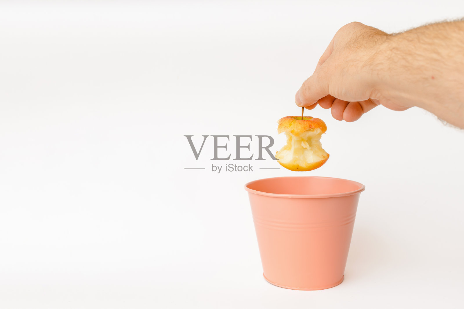 咬过的苹果被扔进垃圾桶处理和回收。白色,背景,选择性聚焦,复制空间。在室内拍摄。照片摄影图片