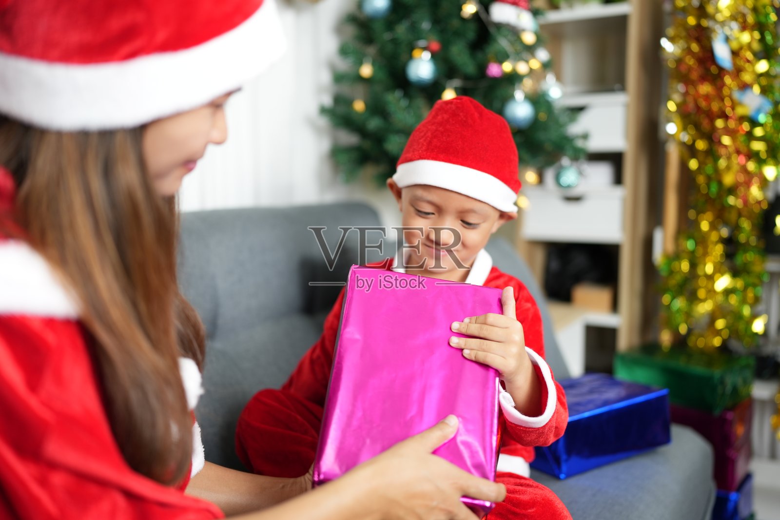 男孩在圣诞节收到妈妈的礼物照片摄影图片
