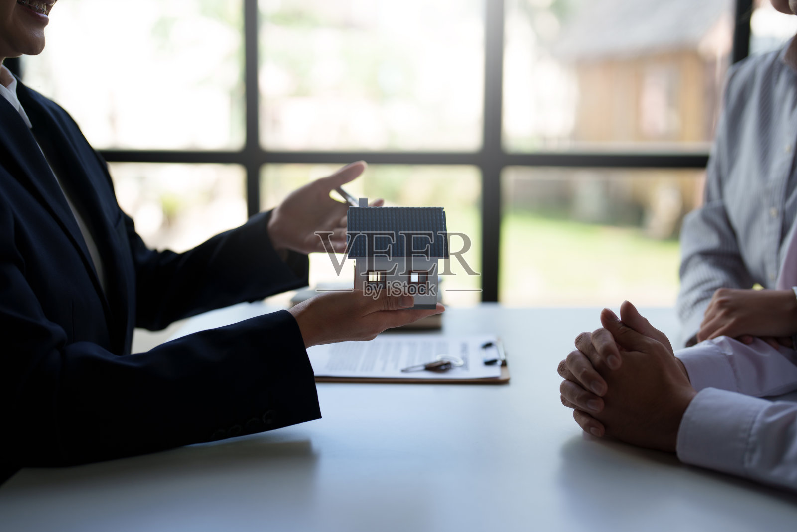 房地产经纪人向客户出售房屋和土地,以提供样板房为例计算首期贷款提供抵押贷款和家庭保险的想法。照片摄影图片