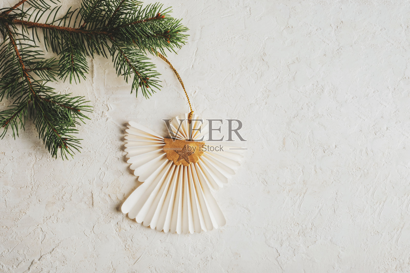 圣诞纸天使挂在树枝上白色纹理的背景。圣诞假期概念。俯视图照片摄影图片