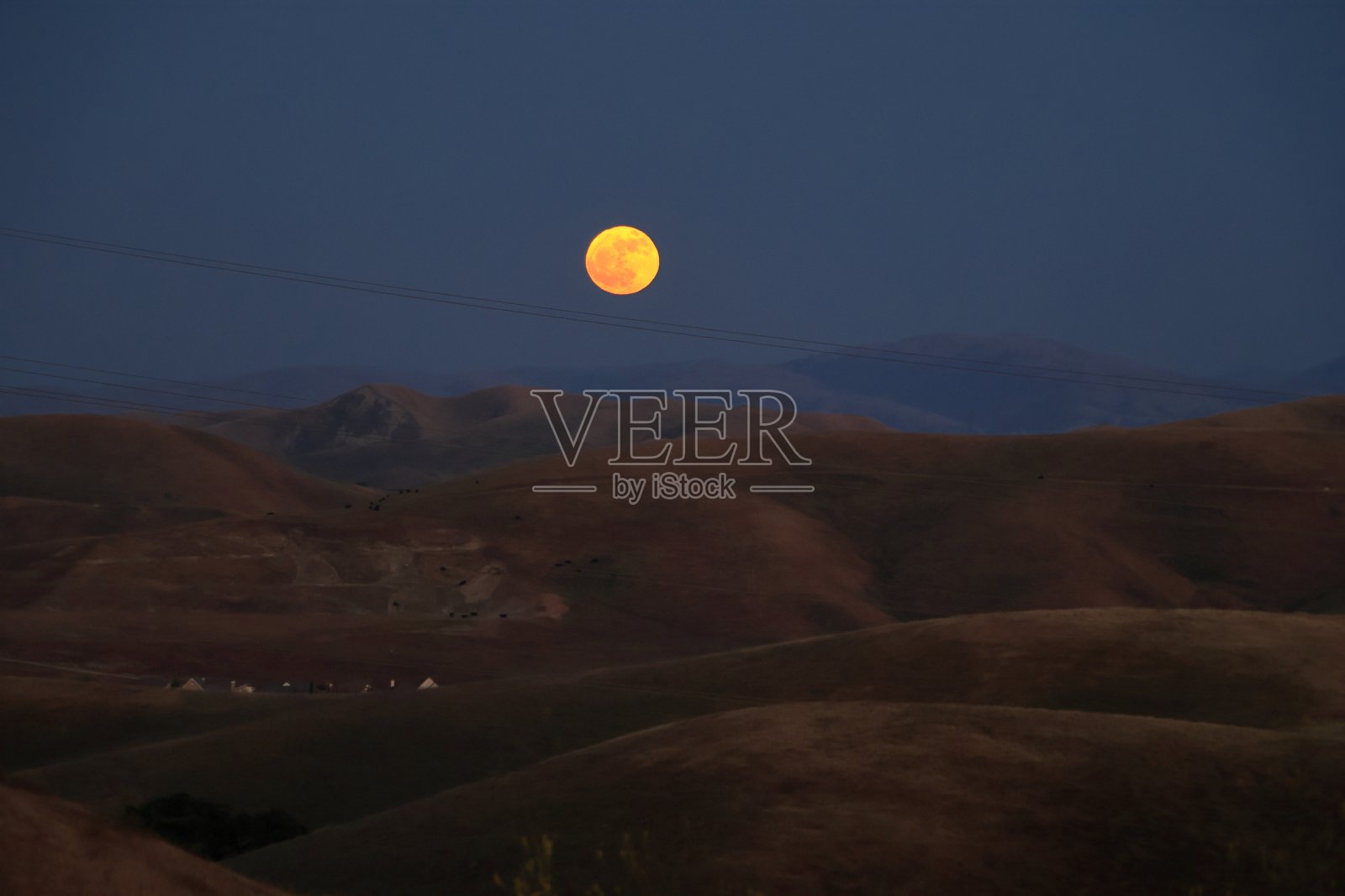 夏天的第一轮满月从北加州的山后升起照片摄影图片