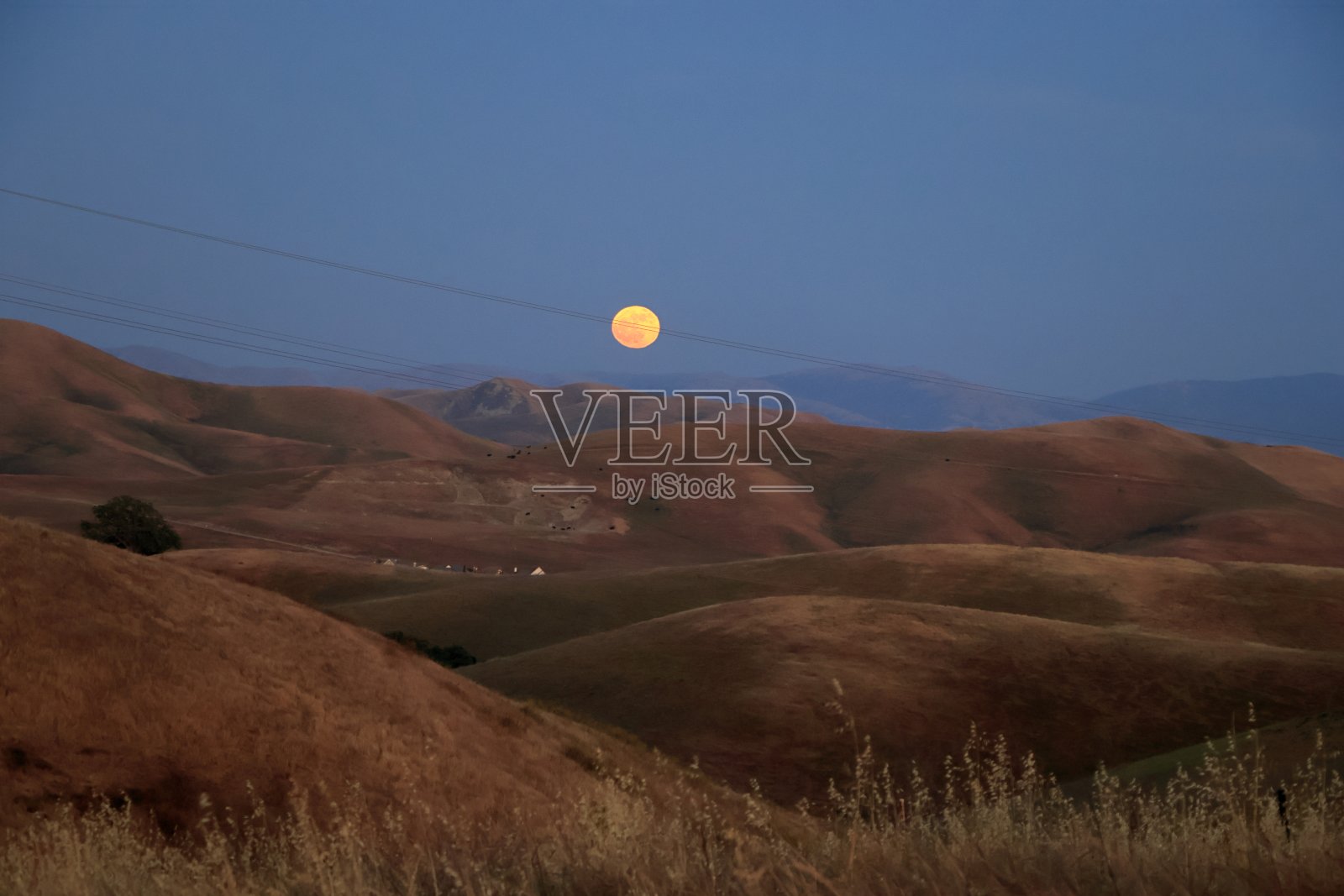 夏天的第一轮满月从北加州的山后升起照片摄影图片