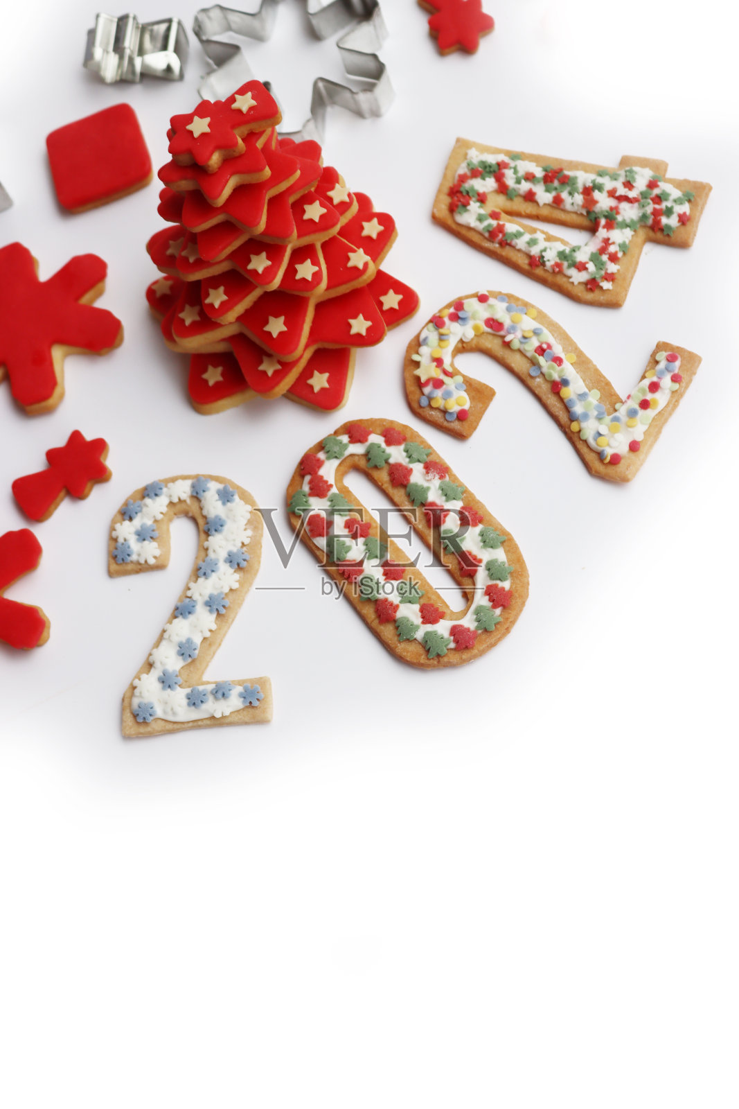 圣诞树由红糖釉的星星形状的饼干和白色的数字2024形状的饼干做成照片摄影图片