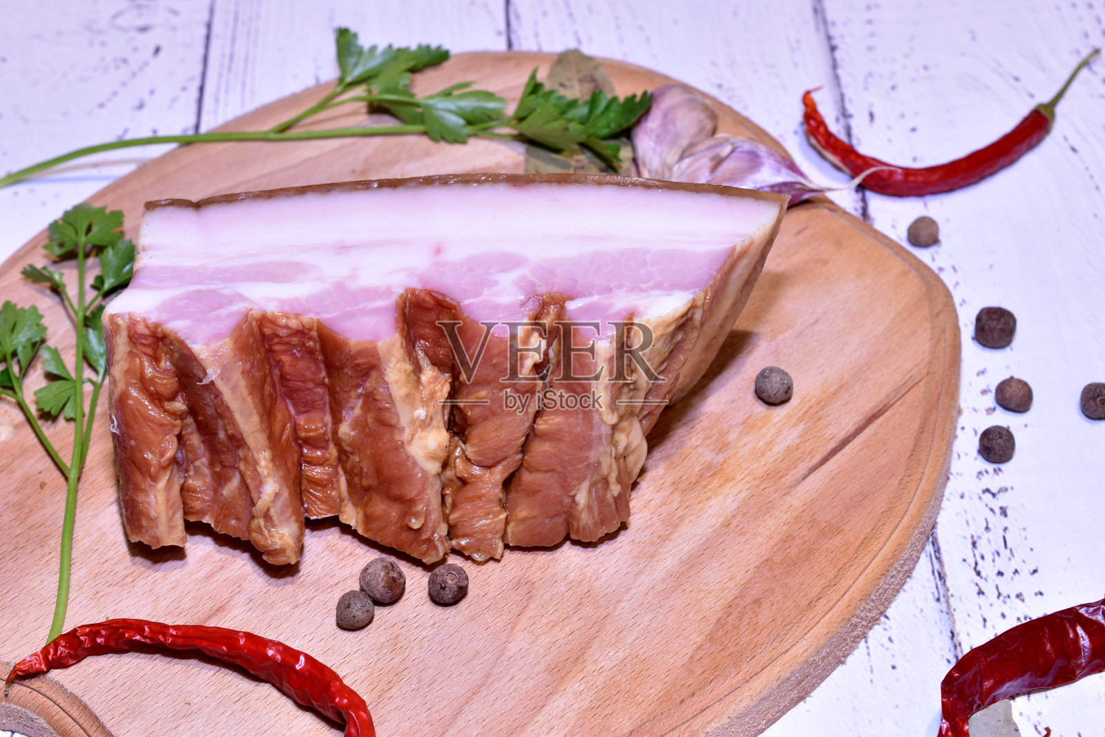 桌上放着一块猪肉和熏肉。照片摄影图片