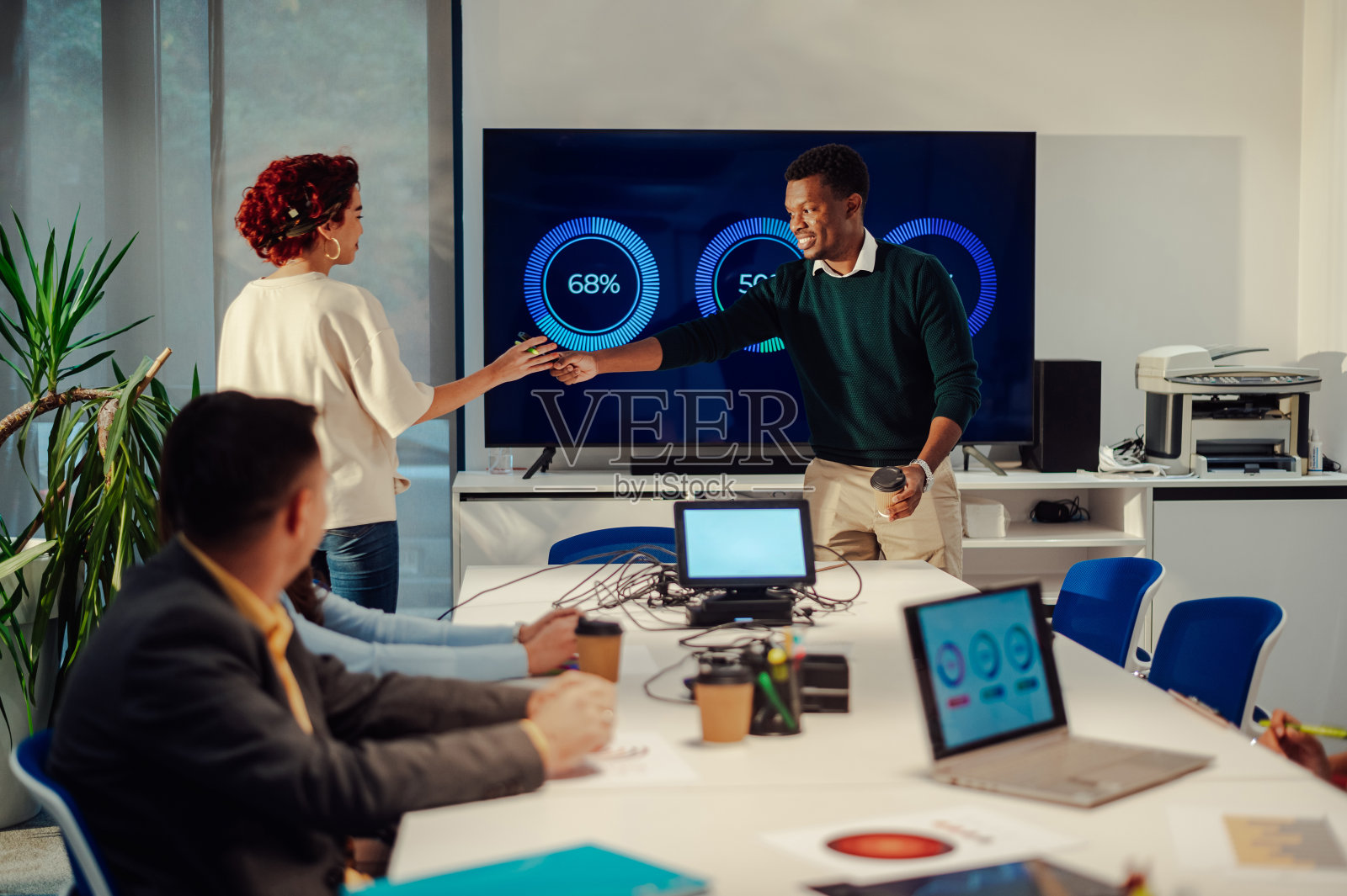 非裔美国人给他的西班牙裔女同事一个记号笔照片摄影图片