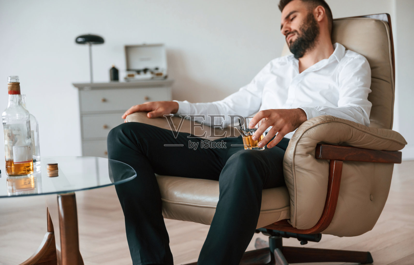 沮丧的年轻男子在室内酗酒照片摄影图片