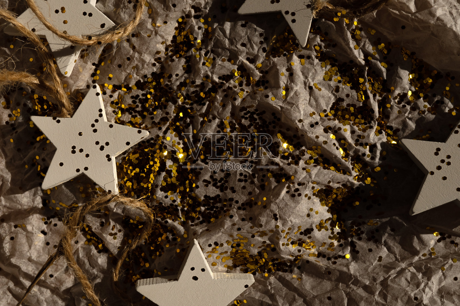 圣诞节的装饰品,闪闪发光地躺在礼物包装纸上。圣诞节的背景照片摄影图片