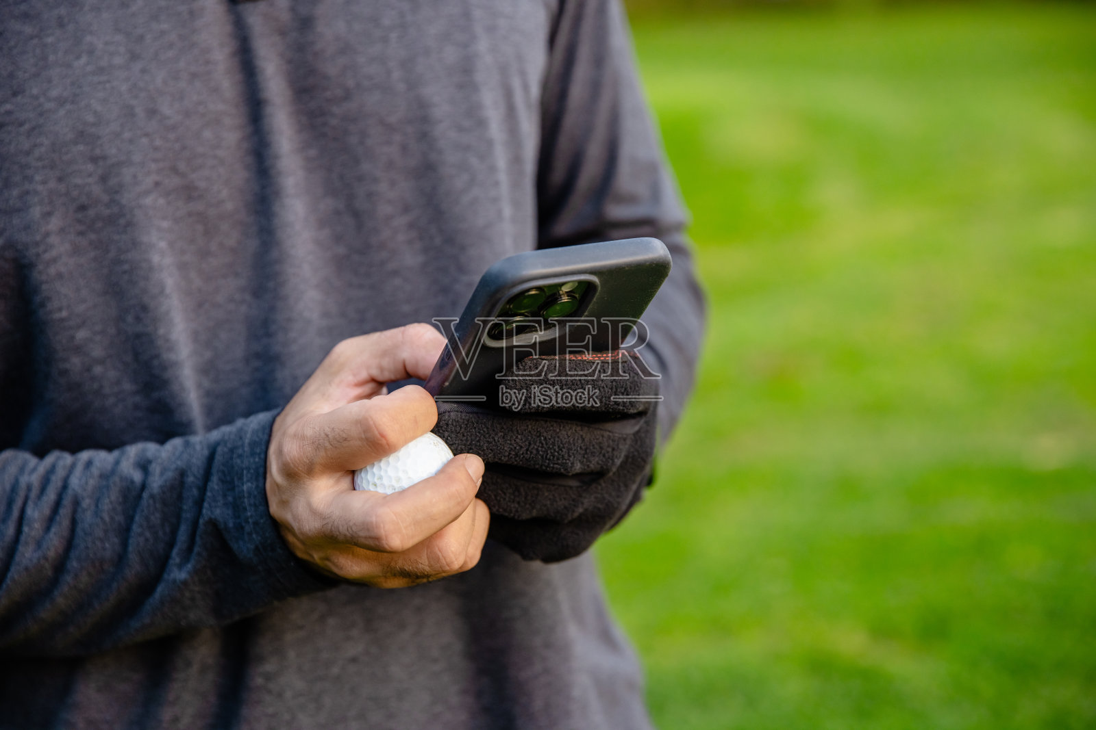 高尔夫球手在高尔夫球场上拿着手机照片摄影图片