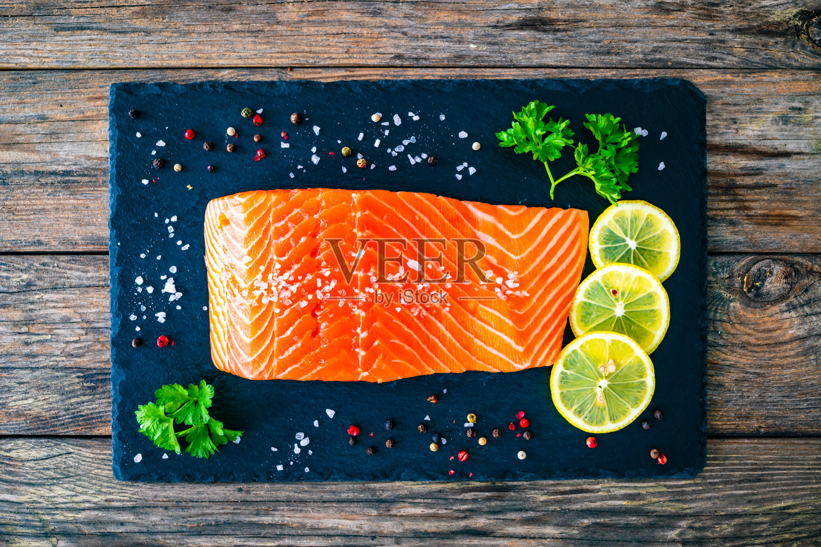 新鲜的生鲑鱼排在石质砧板上照片摄影图片
