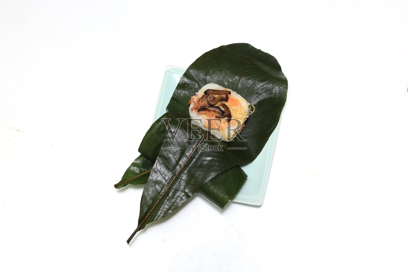 寿司包裹在白玉兰叶中,被称为鹤巴竹石,孤立在白色的背景上。照片摄影图片