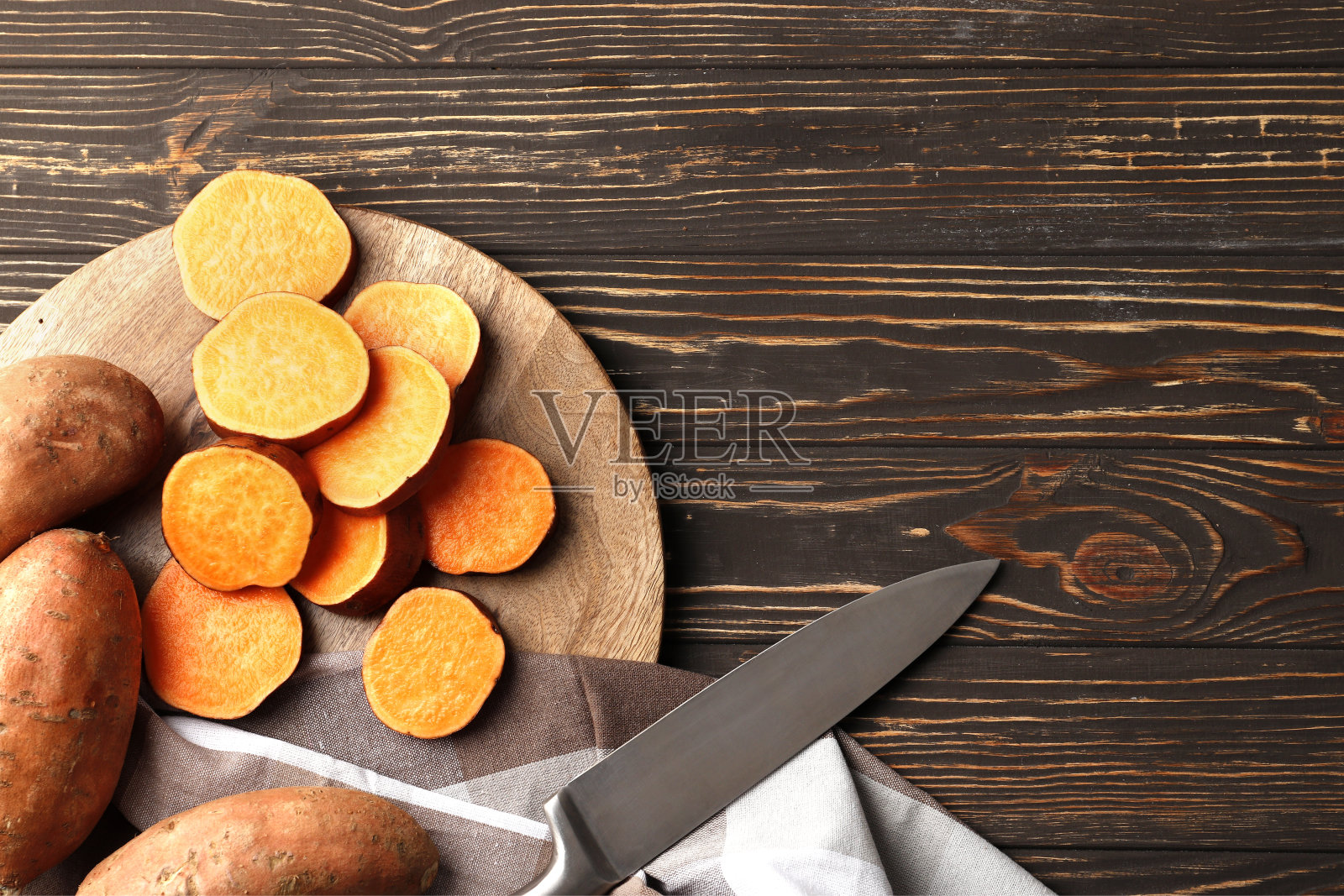 木桌背景上新鲜成熟的红薯的构图。特写镜头。照片摄影图片