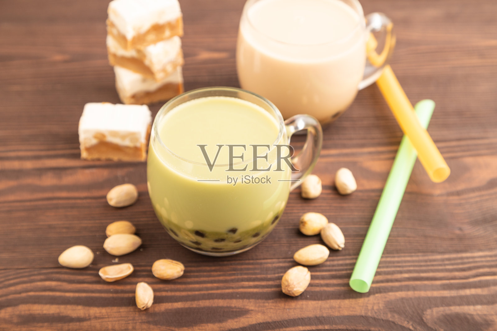 在棕色木制的玻璃杯里装着开心果和焦糖的珍珠奶茶,侧视图,选择性聚焦。照片摄影图片