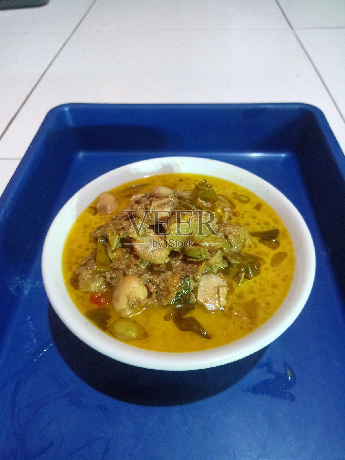 椰奶籽面包汤,白色碗,蓝色托盘照片摄影图片