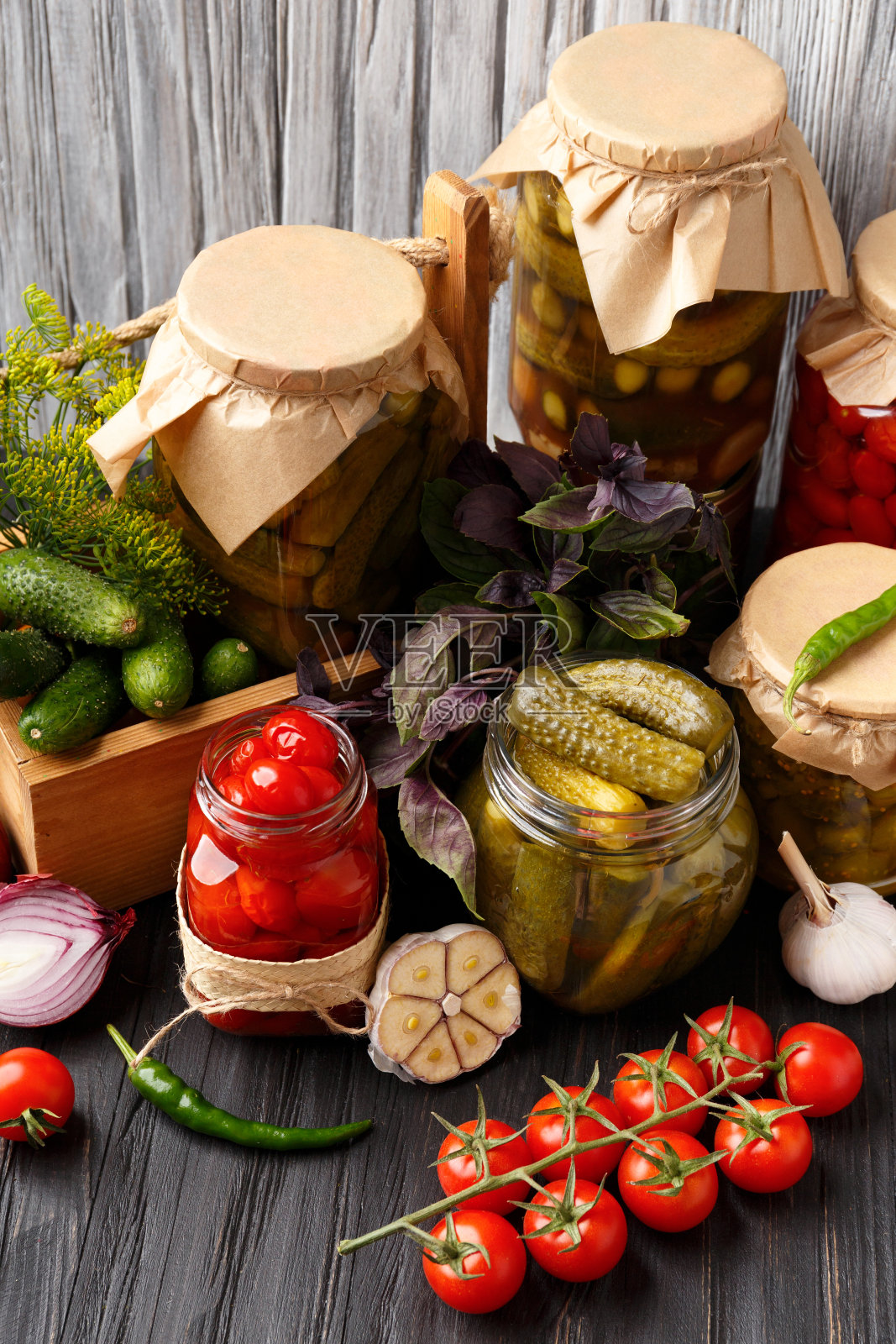 木制背景上的罐装圣女果和黄瓜。照片摄影图片