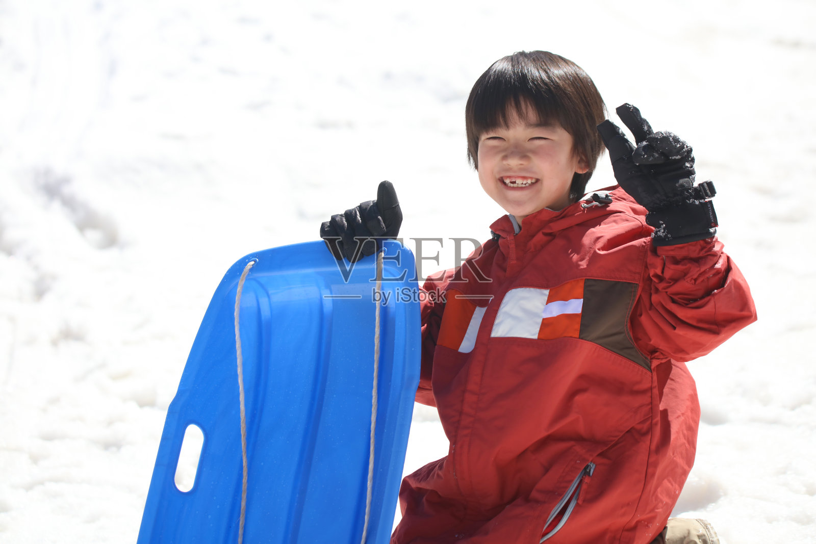 男孩在雪橇上玩照片摄影图片
