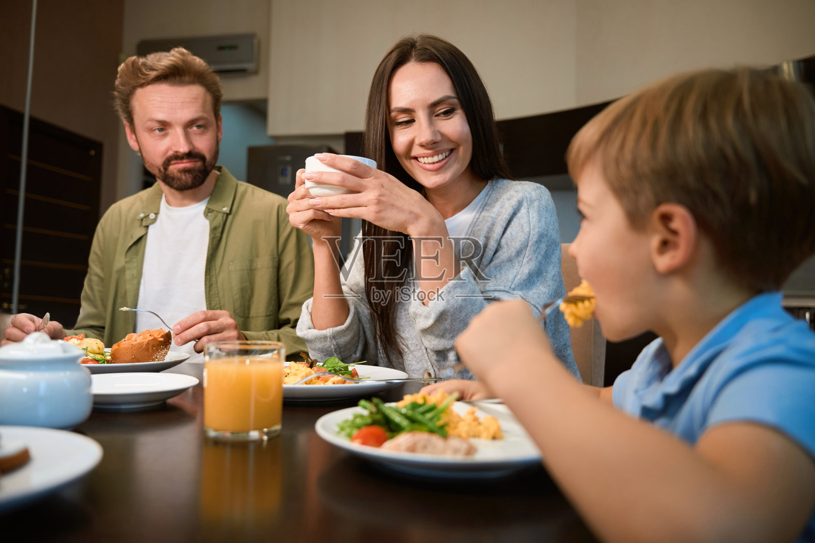 一名女子在酒店与家人共进早餐时喝着咖啡照片摄影图片