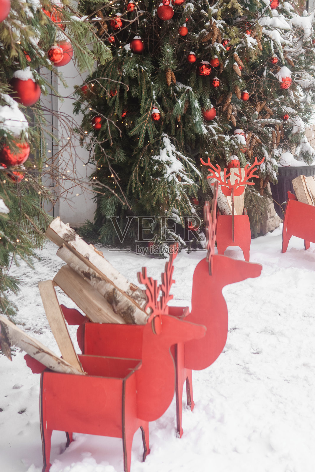 咖啡馆门口的圣诞树上装饰着红气球。街头圣诞装饰。照片摄影图片